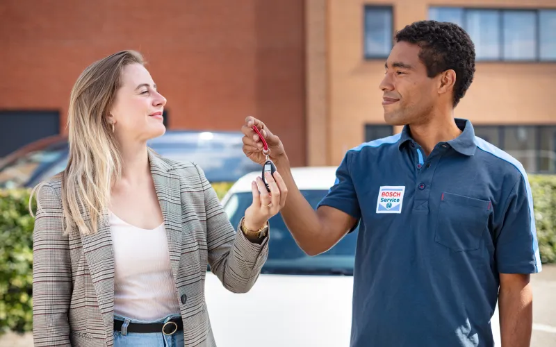 Bosch Car Service medewerker overhandigt de autosleutel aan de klant